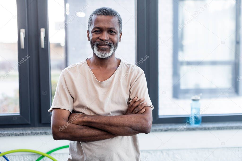 African american man crossing arms and looking at camera in gym 