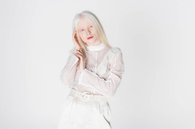 Genç albino ve sarışın kadın beyaz üzerinde yalnız poz veriyorlar. 