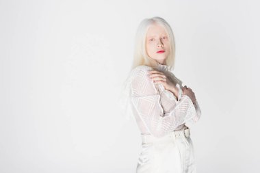 Güzel albino kadın beyaz poz verirken kameraya bakıyor. 