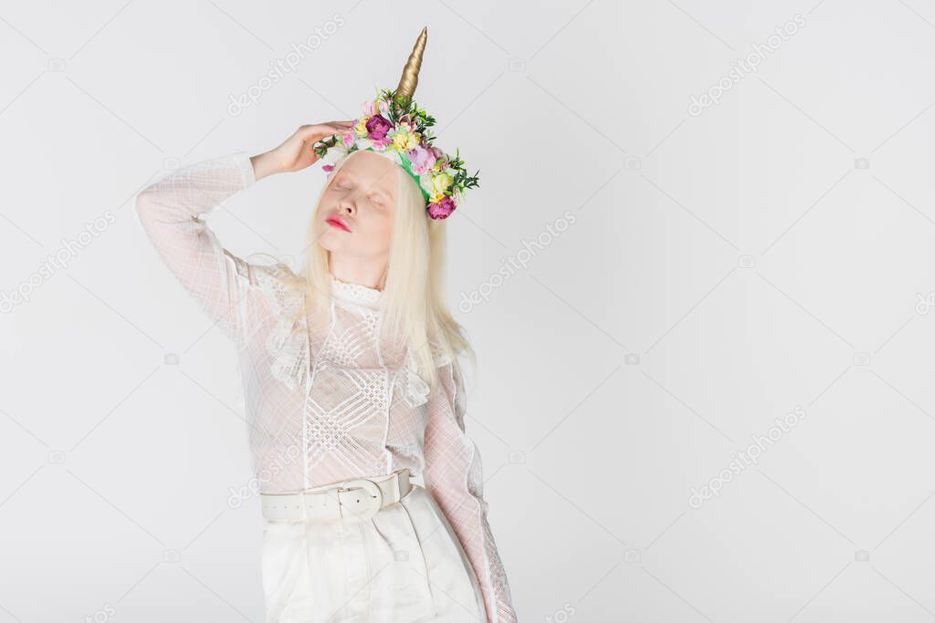 Albino and blonde woman in blouse and wreath with flowers isolated on white
