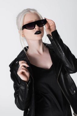 Deri ceketli ve beyaz gözlüklü, modaya uygun albino model.
