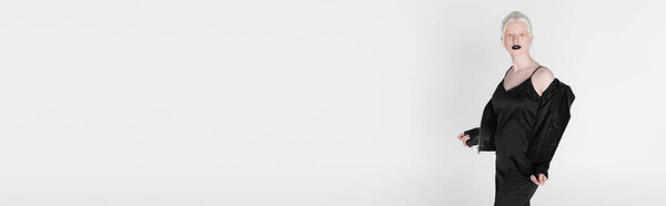 Молодая модель альбиноса снимает кожаную куртку, изолированную на белом, баннер 