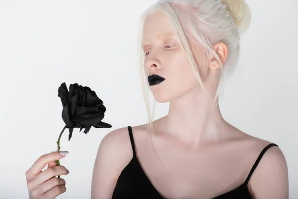 Albino Vrouw Met Zwarte Lippen Kijken Naar Roos Geïsoleerd Wit — Stockfoto