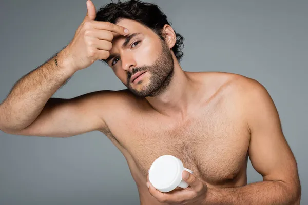 Hombre Tatuado Sosteniendo Contenedor Aplicando Crema Facial Aislada Gris —  Fotos de Stock