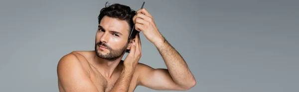 Concentrated Shirtless Man Brushing Wavy Hair Comb Isolated Grey Banner — Stock Photo, Image