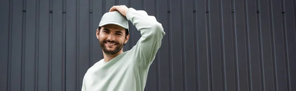 Smiling Man Sweatshirt Adjusting Cap Metallic Fence Banner — Stock Photo, Image