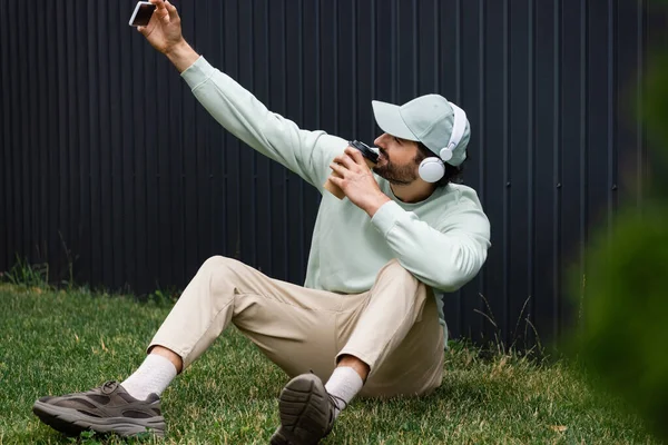 Homme Positif Dans Les Écouteurs Sans Fil Prenant Selfie Tout — Photo