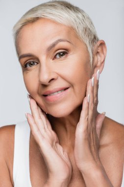 # Mutlu yaşlı kadın gülümserken # # Gri ellerle yüzlerine dokunurken #