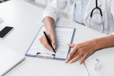 Doktorun reçeteli ilaç yazma görüntüsü masanın üstünde. 