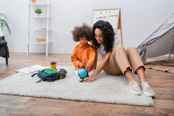 Mujer Afroamericana Sosteniendo Globo Cerca Hija Sala Estar — Foto de Stock