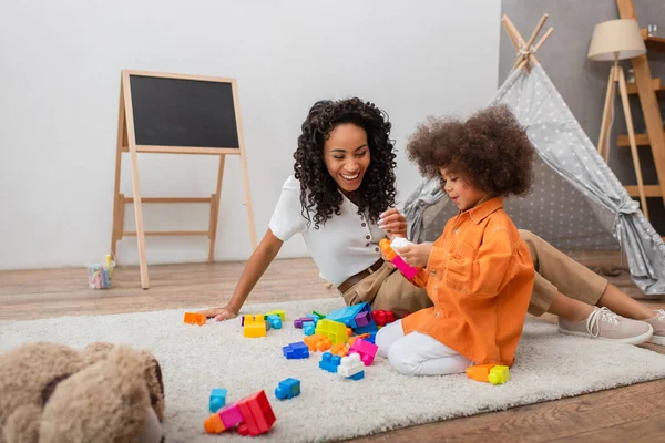 Positivo Afro Americano Mãe Sentado Perto Criança Com Blocos Construção — Fotografia de Stock