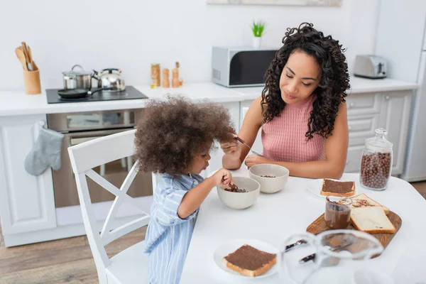 Young African American Woman Holding Spoon Kid Cereal Bread Kitchen — Stock Photo, Image
