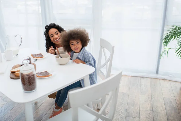 Sonriente Niño Afroamericano Mirando Cámara Cerca Mamá Desayuno Cocina — Foto de Stock