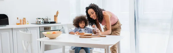 Happy African American Woman Holding Chocolate Paste Kid Bread Kitchen — Stock Photo, Image