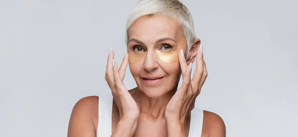 Smiling Senior Woman Applying Collagen Eye Patches Isolated Grey Banner — Stock Photo, Image