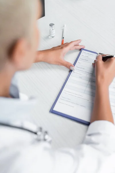 High Angle View Blurred Doctor Writing Prescription Syringe Desk — Stock Photo, Image