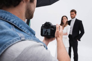 Profesyonel fotoğrafçı, beyazlar üzerinde bulanık modellerin fotoğrafını çekiyor.