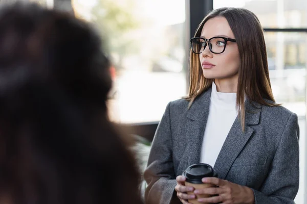 Young Businesswoman Eyeglasses Holding Coffee Blurred Colleague — Fotografia de Stock