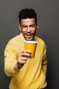 Gözlüklü, gri bardaklı, bulanık Afrikalı Amerikalı adam.