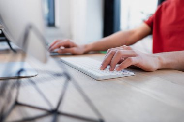 Ofiste bilgisayar klavyesi kullanan yöneticinin kırpılmış görünümü