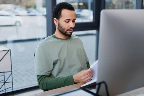 Bearded African American Man Looking Documents Blurred Computer Monitor — Stock Photo, Image