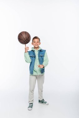 Tam boy mutlu çocuk basketbol topunu parmak üstüne parmak üstüne beyaz.