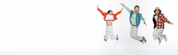 Full Length Stylish Kids Smiling While Levitating White Banner — Stockfoto