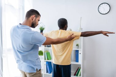 Rehabilitasyon uzmanı, klinikteki olgun Afrikalı Amerikalı adamı teşhis ediyor.