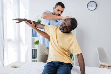 Klinikte kollarını ve boynunu uzatan bir rehabilitasyon uzmanı.