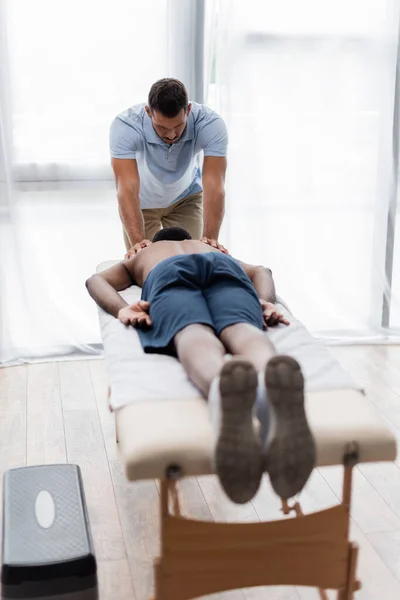 Joven Fisioterapeuta Tratamiento Afroamericano Hombre Acostado Mesa Masaje — Foto de Stock