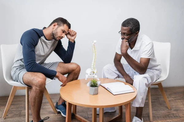 Hombre Joven Maduro Afroamericano Médico Mirando Modelo Columna Vertebral Cerca —  Fotos de Stock