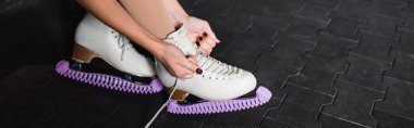 Artistik patinaj ayakkabısı bağlayan genç kadın manzarası, afiş