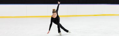 full length of professional figure skater in black bodysuit skating with outstretched hands in ice arena, banner clipart