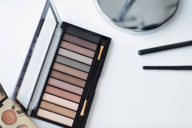 Masadaki göz gölgeleri ve kozmetik fırçaların üst görünümü 