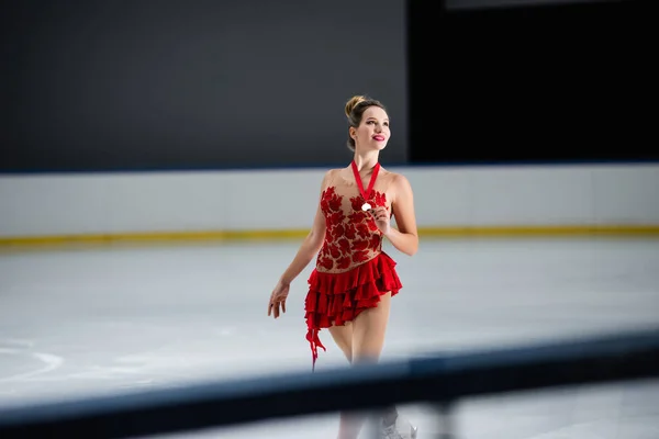 Kırmızı Elbiseli Pozitif Artistik Patinajcı Buz Pistinde Altın Madalya Taşıyor — Stok fotoğraf