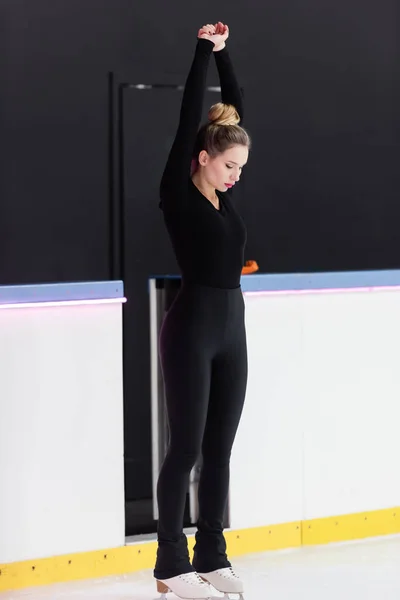 Full Length Young Figure Skater Black Bodysuit Ice Skates Stretching — Foto Stock