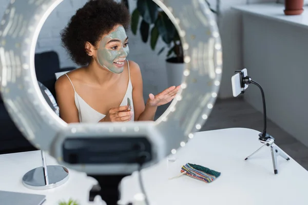 Blogger Afroamericano Sonriente Con Máscara Arcilla Cara Sosteniendo Cepillo Cosmético — Foto de Stock