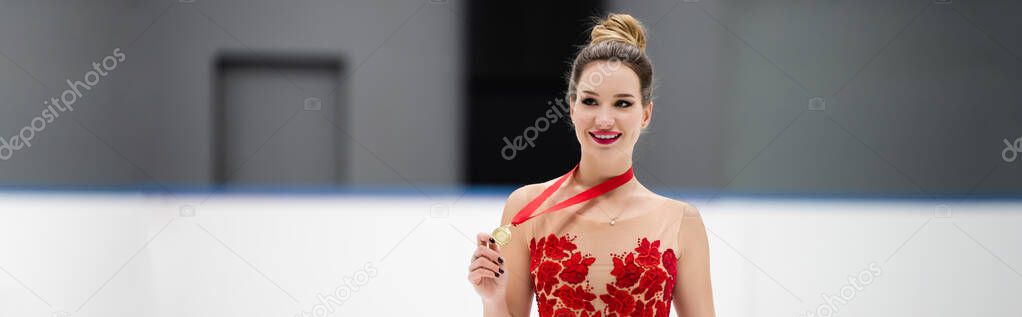 happy figure skater in red dress holding golden medal, banner