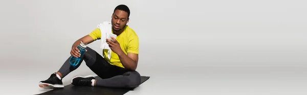 Full Length African American Sportsman Sitting Fitness Mat Using Smartphone — Stock Photo, Image