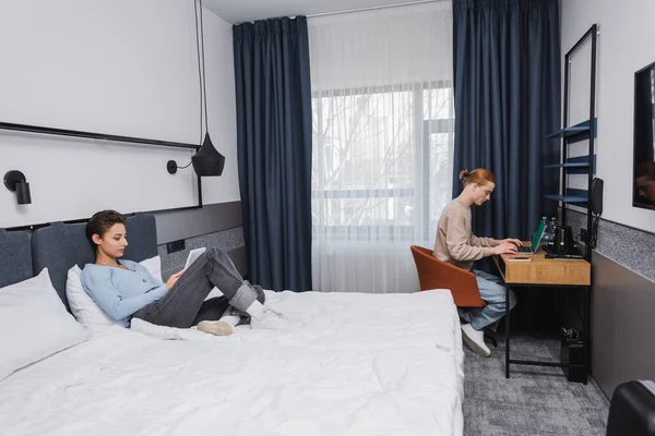 Young Couple Using Devices Modern Hotel Room — стоковое фото