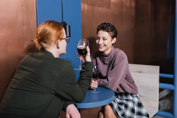 Mujer Alegre Sosteniendo Vino Cerca Novio Borroso Hotel — Foto de Stock