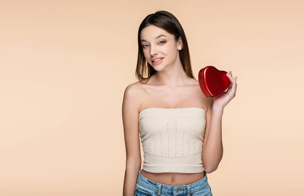 Mujer Joven Positiva Sosteniendo Caja Metálica Roja Forma Corazón Aislada — Foto de Stock