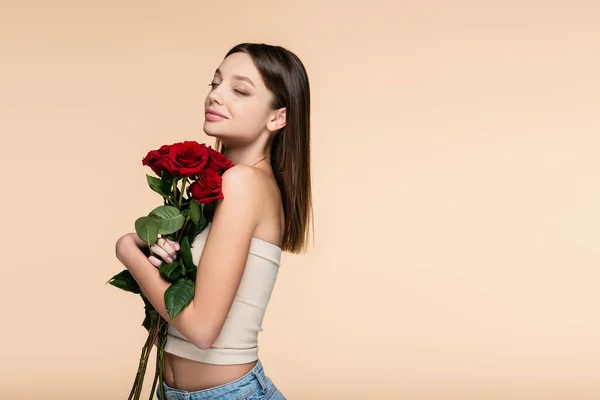 Feliz Joven Con Los Ojos Cerrados Sosteniendo Rosas Rojas Aisladas — Foto de Stock