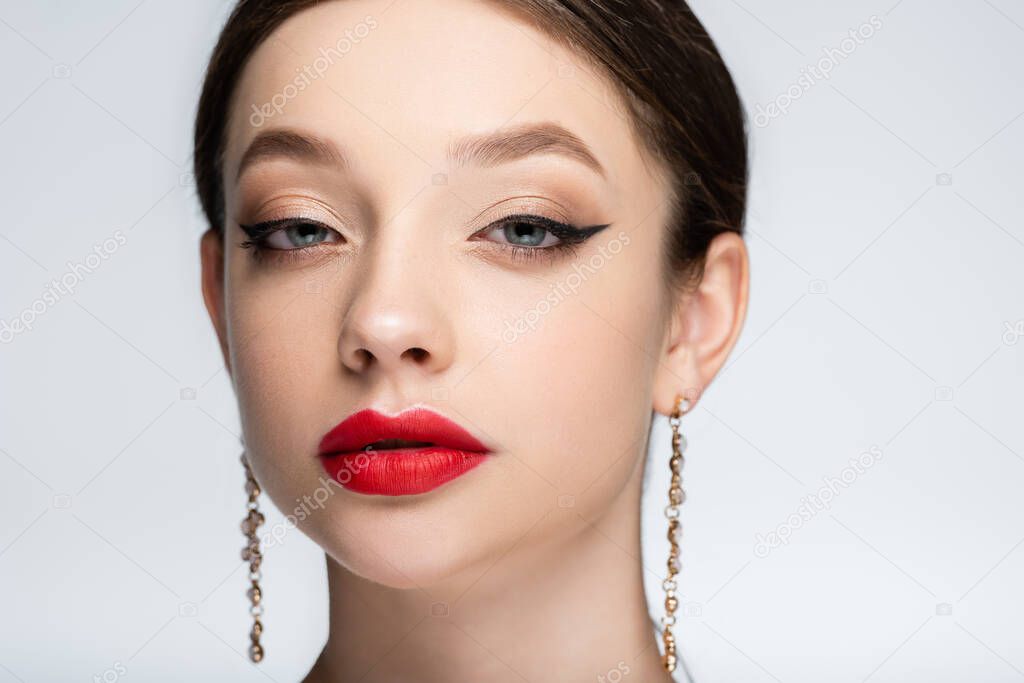 pretty woman with bright makeup looking at camera isolated on grey