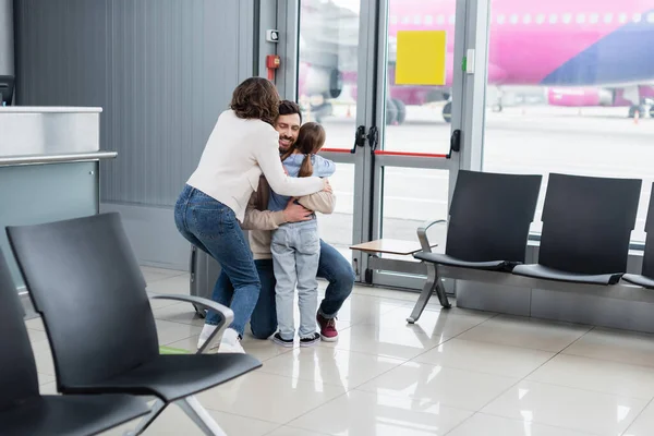 空港で家族を抱きしめる陽気な男 — ストック写真