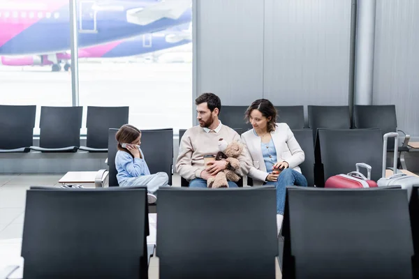 Happy Parents Looking Daughter Talking Smartphone Airport — Stock fotografie