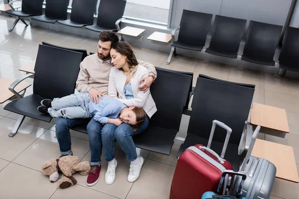 High Angle View Girl Sleeping Knees Tired Parents Airport Lounge — стоковое фото