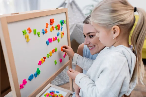 Child Smiling Mom Playing Colorful Magnets Easel Home — Stock fotografie