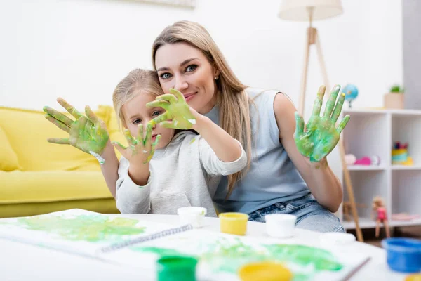 Woman Looking Camera Daughter Looking Hands Paint Home —  Fotos de Stock