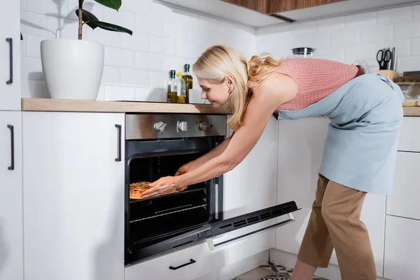 Seitenansicht Einer Reifen Frau Die Hause Kuchen Aus Dem Ofen — Stockfoto